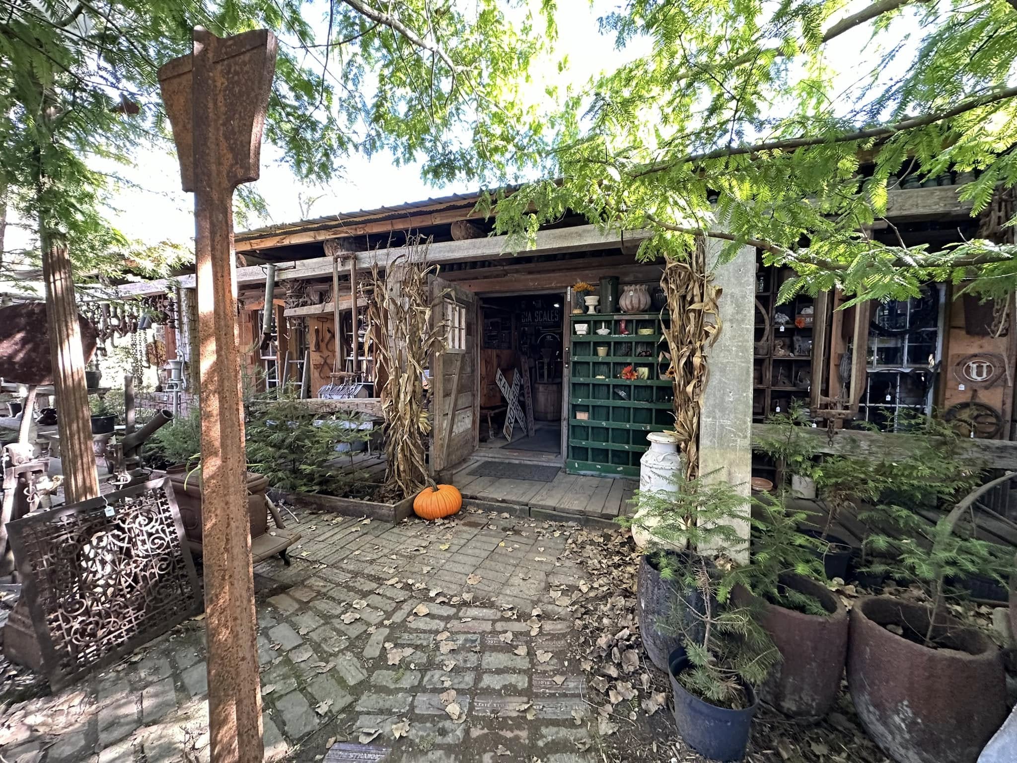  A long logcabin infront of a small courtyard of railroad related stuff